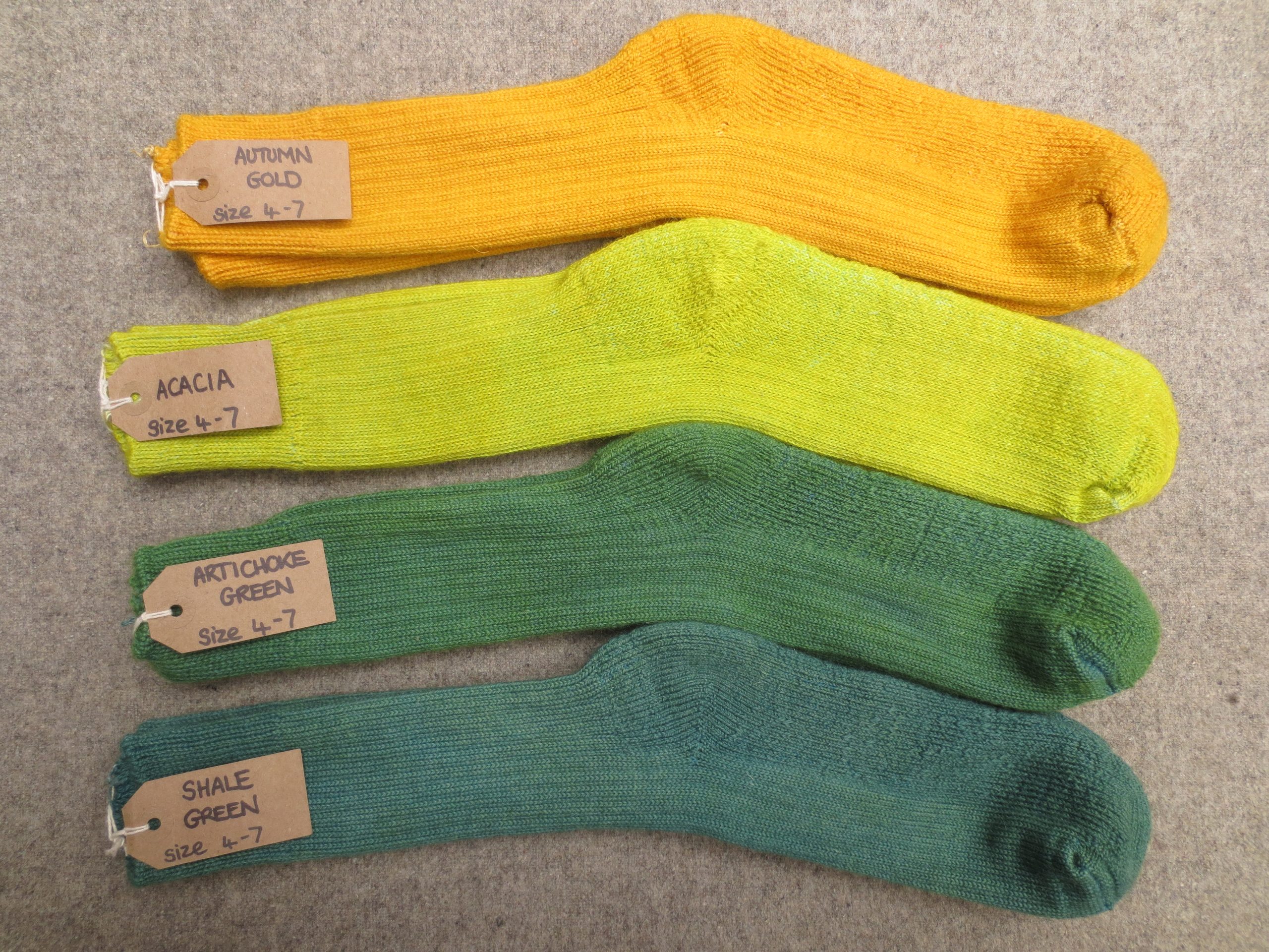 4 pairs of socks labelled Autumn Gold, Acacia, Artichoke Green and Shale Green