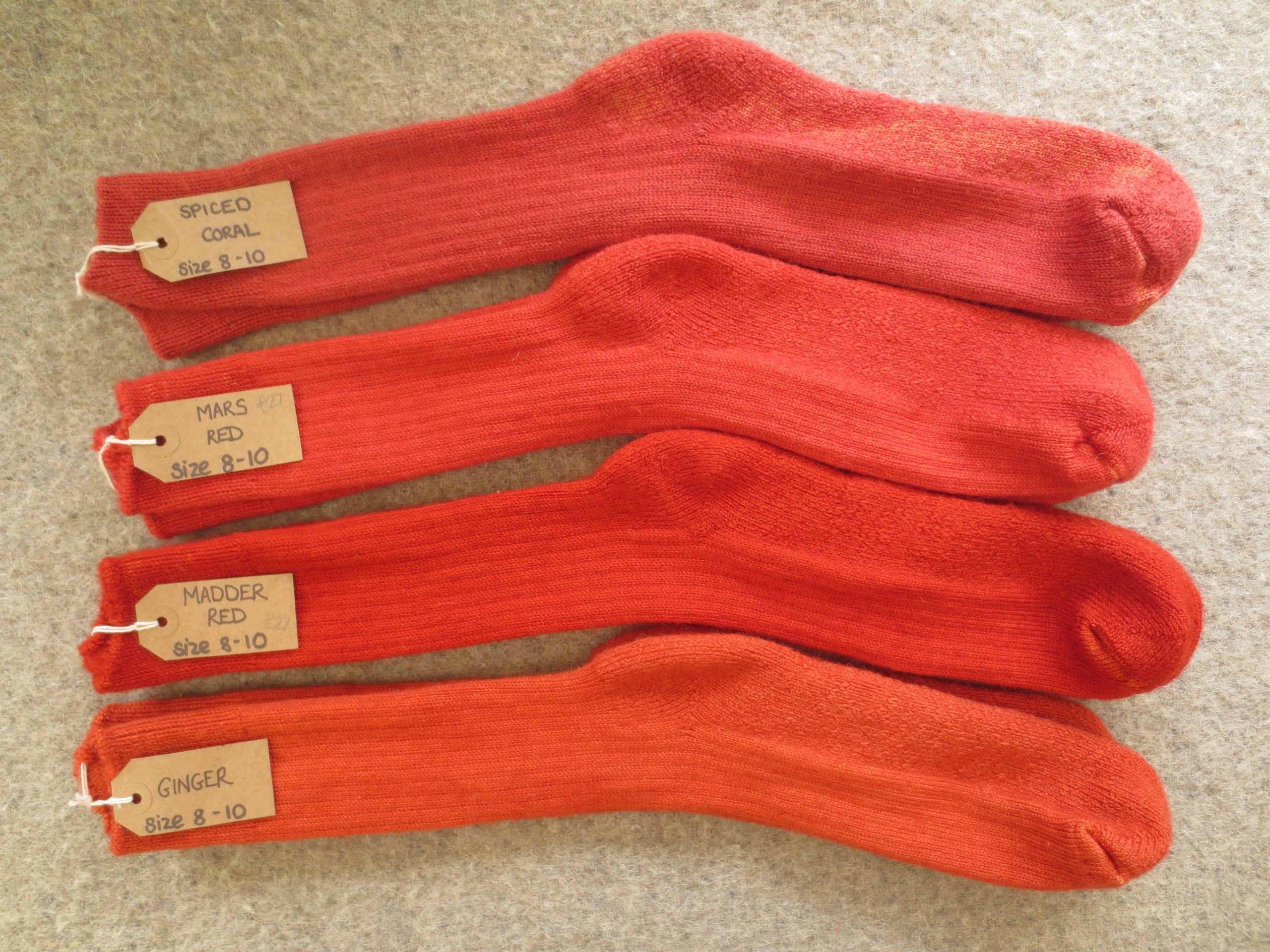 4 pairs of socks labelled Spiced Coral, Mars Red, Madder Red and Ginger