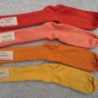 4 pairs of wool socks labelled madder red, melon, sun orange and amber