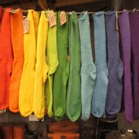 Hanging woollen socks in a naturally dyed rainbow of colours