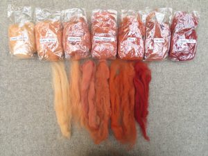 7 small bags of wool labelled almond cream, coral gold, burnt orange, aragob, chilli, fox red and barn red