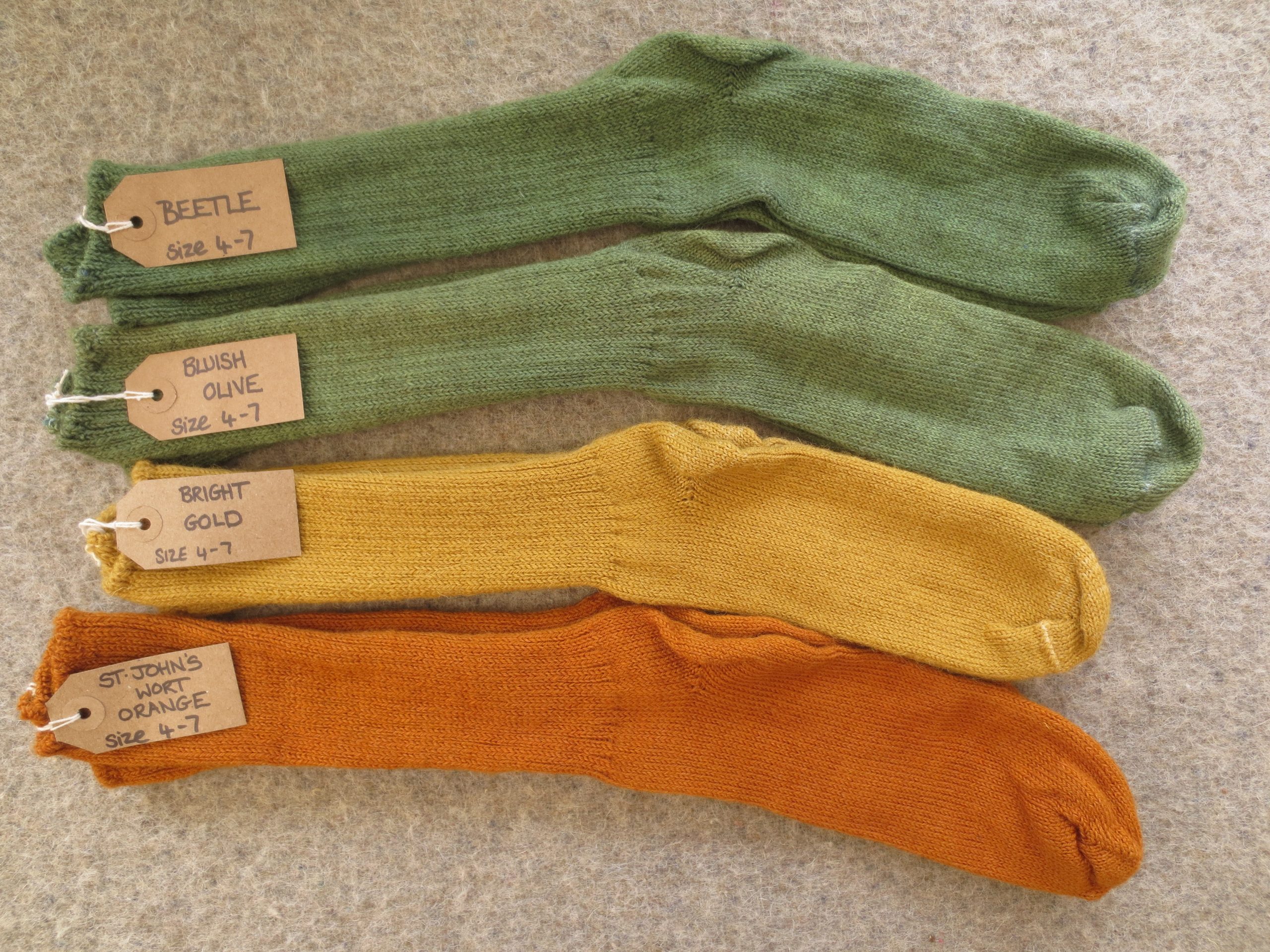 4 pairs of socks labelled Bluish Olive, Beetle, Bright Gold and St John's Wort Orange