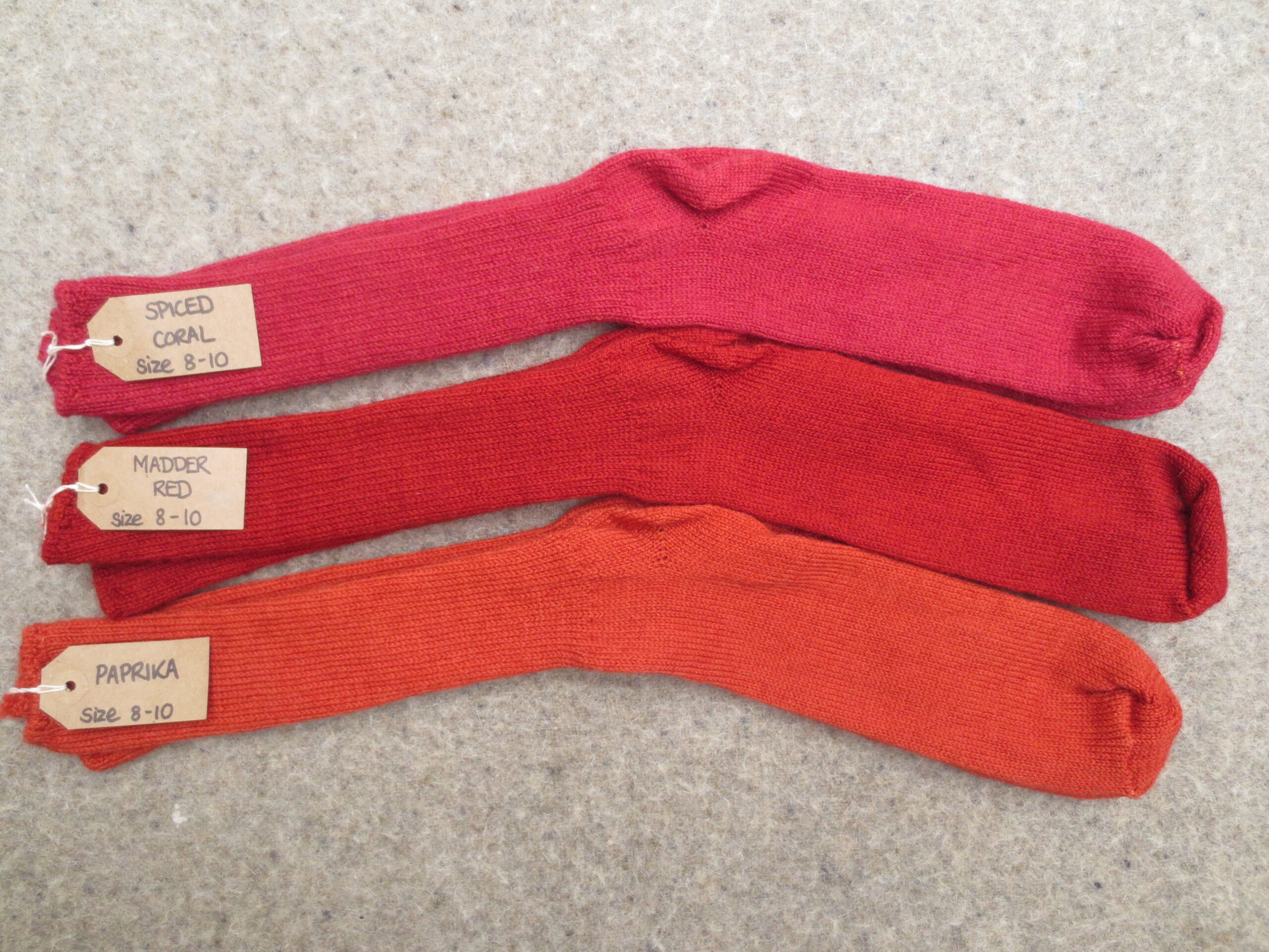3 pairs of socks labelled Spiced Coral, Madder Red and Paprika