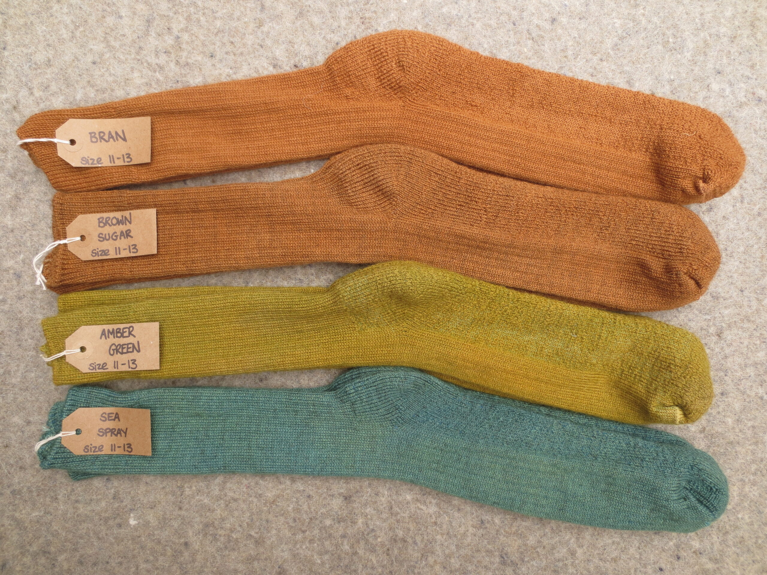 4 pairs of socks labelled Bran, Brown Sugar, Amber Green and Sea Spray