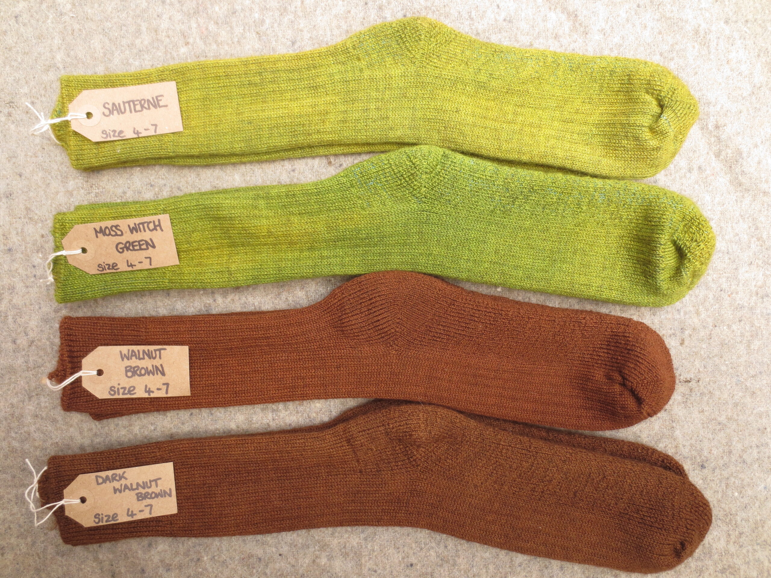 4 pairs of socks labelled Sauterne, Moss Witch Green, Walnut Brown and Dark Walnut Brown