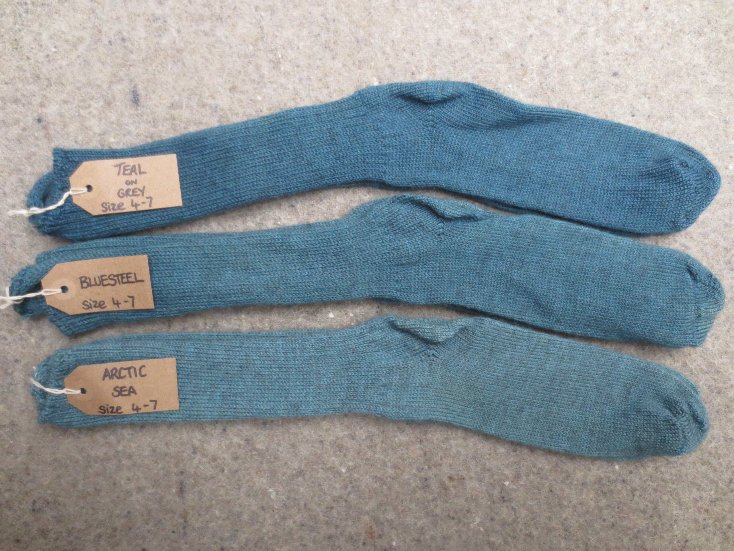 3 pairs of socks labelled Arctic Sea, Bluesteel, Teal on Grey