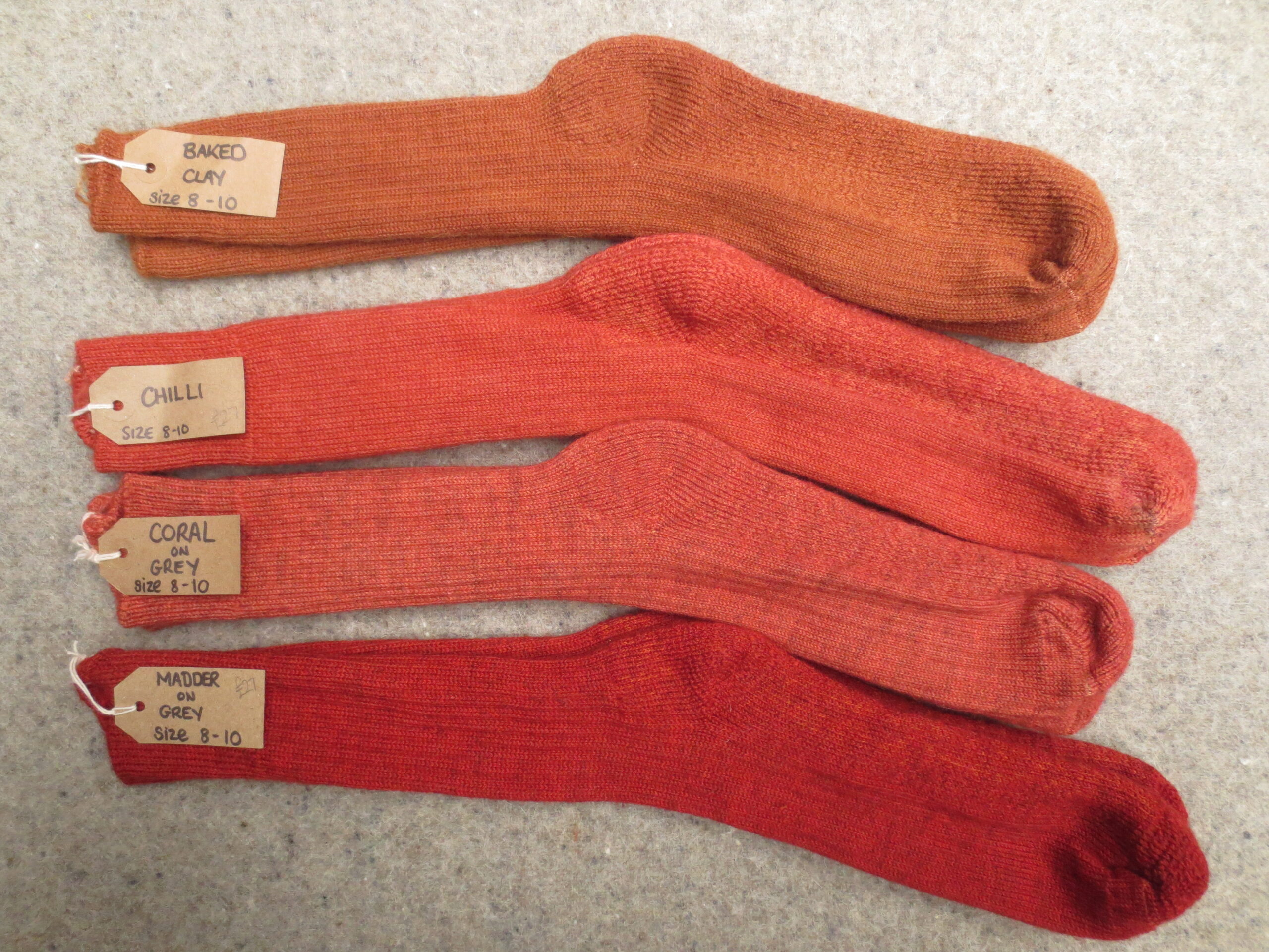 4 pairs of socks labelled Baked Clay, Chilli, Coral on Grey and Madder on Grey