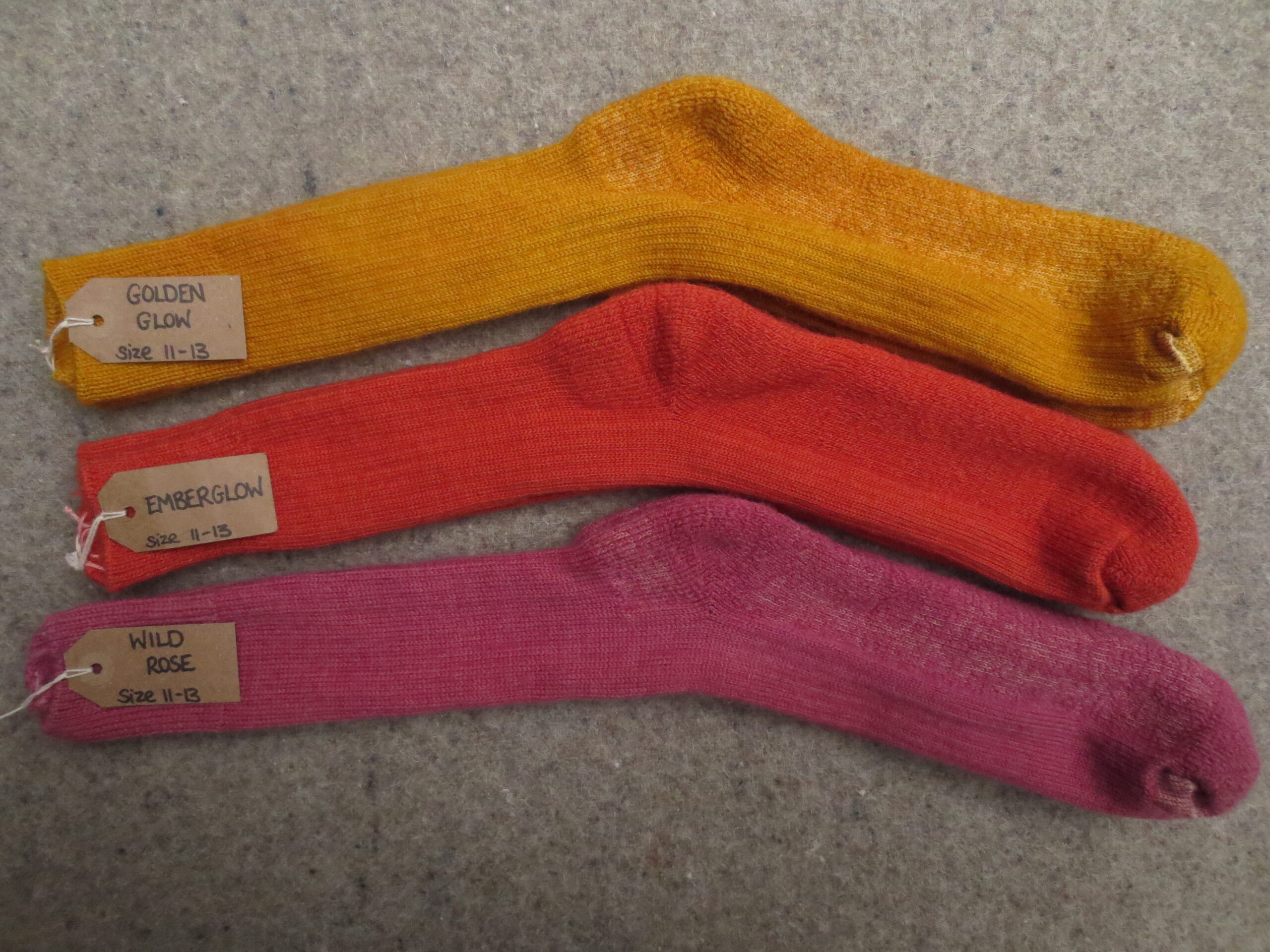 3 pairs of socks labelled Wild Rose, Ember Glow and Golden Glow
